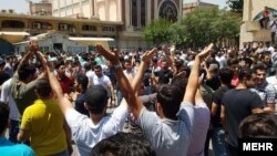 Iranians protest at Tehran's Grand Bazaar on the morning of June 25 after the black-market exchange rate for the rial currency fell by more than 10 percent in a single day.