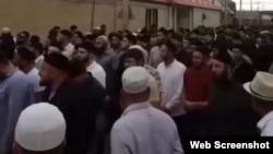 A screen grab from a video showing thousands of people gathering in the Chechen village of Geldagen for the burial of Yusup Temerkhanov on August 4.
