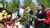 Mourners place flowers at the grave of English teacher Elvira Ignatyeva, who was killed during the shooting in Kazan, at her funeral on May 12.