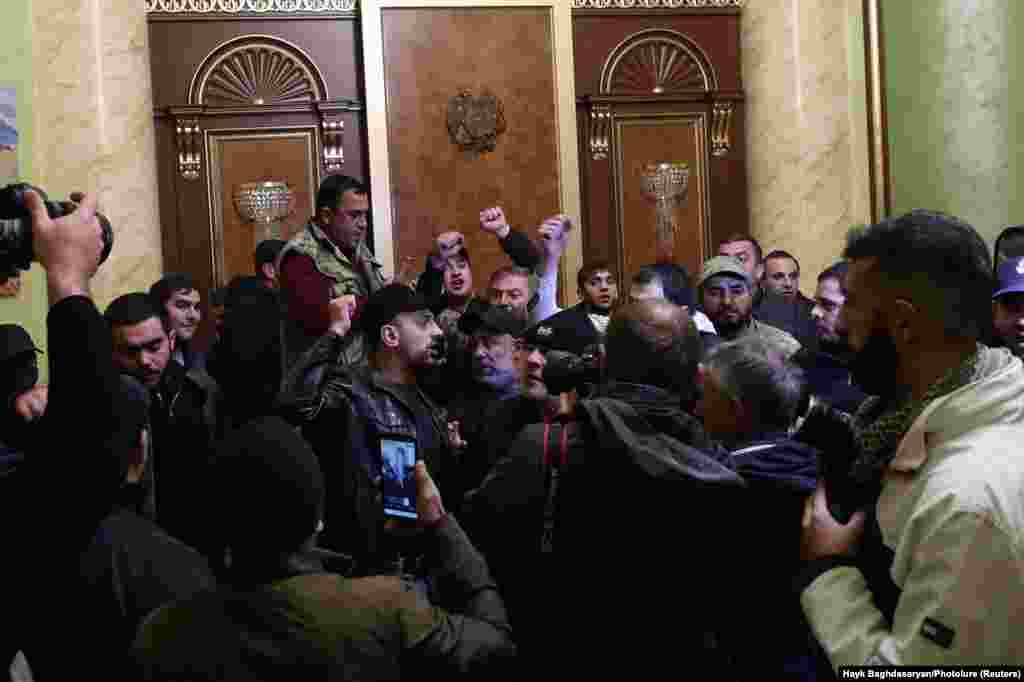 People stand angrily at the entrance to government headquarters in Yerevan. Armenia's Defense Ministry released a statement about the conflict in Nagorno-Karabakh saying "it is time to stop the bloodshed." 