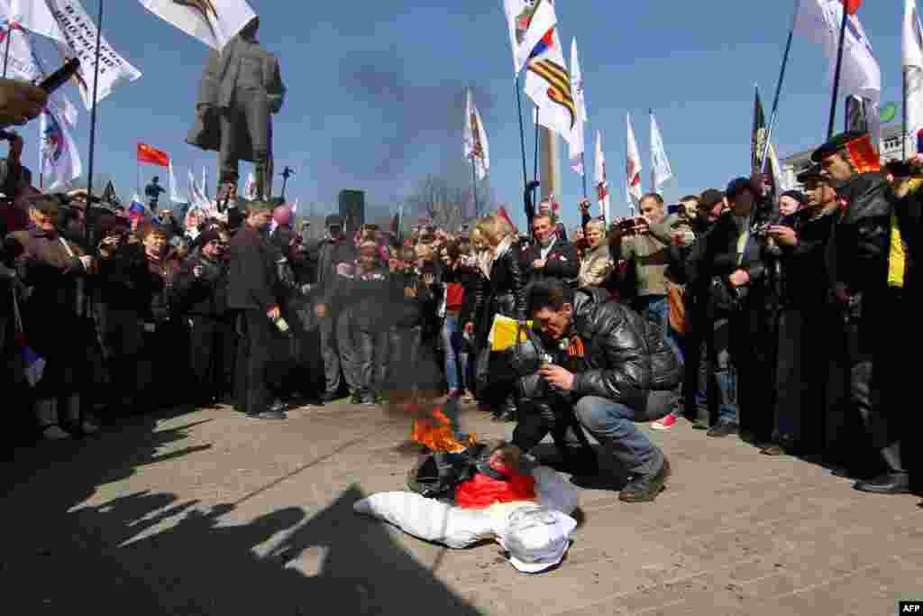 During the rally in Donetsk, a pro-Russia supporter burns an effigy of Stepan Bandera (1909 –1959), one of the leaders of the national movement which fought for Ukrainian independence in the mid-20th century.