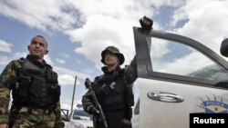 Members of the Kosovar special police forces stand by their vehicle in the ethnically divided town of Mitrovica on July 26.