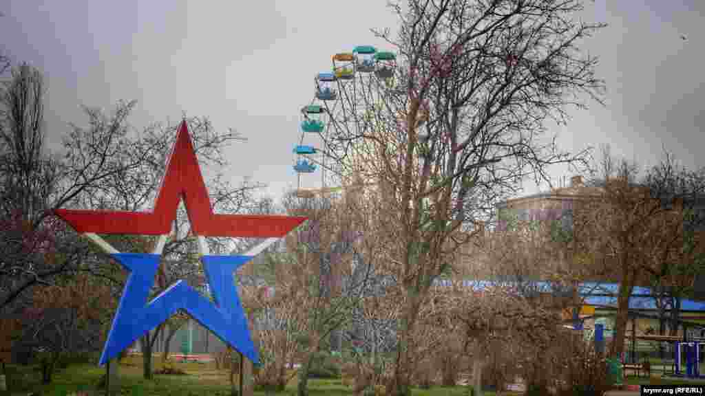Разноцветные детские аттракционы на набережной пустуют. В центре сквера установлена кованая металлическая звезда. Местная жительница, повстречавшаяся корреспондентам, шутит: «В Крыму в этом плане все стабильно. У нас в центре города может стоять или крест православный, или звезда советская»