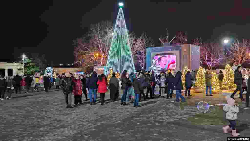 У главной городской елки установлен экран, на котором транслируют праздничные передачи телеканала «Россия 1»