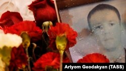 Red carnations are placed near a photo of Russian pilot Roman Filipov, who was shot down in Syria, outside the Russian Defense Ministry in Moscow.