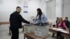 Një qytetar duke hedhur votën në kutinë e votimit në një qendër votimi në Prishtinë, pasi votoi mëngjesin e hershëm në zgjedhjet lokale, Prishtinë, 12 tetor 2025.