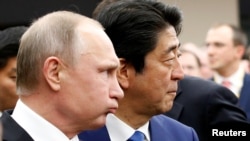 Владимир Путин и Синдзо Абэ на российско-японском деловом форуме в Токио. 16 декабря