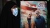 An Iraqi woman in Baghdad carries a portrait of Iranian Major General Qasem Soleimani (left) and Iraqi militiaman Abu Mahdi al-Mohandes at an event to mark the first anniversary of their death in a U.S. air strike.