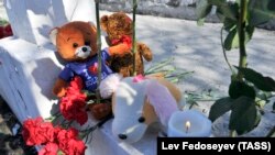 Люди несут свечи и игрушки в память о погибших в трагедии