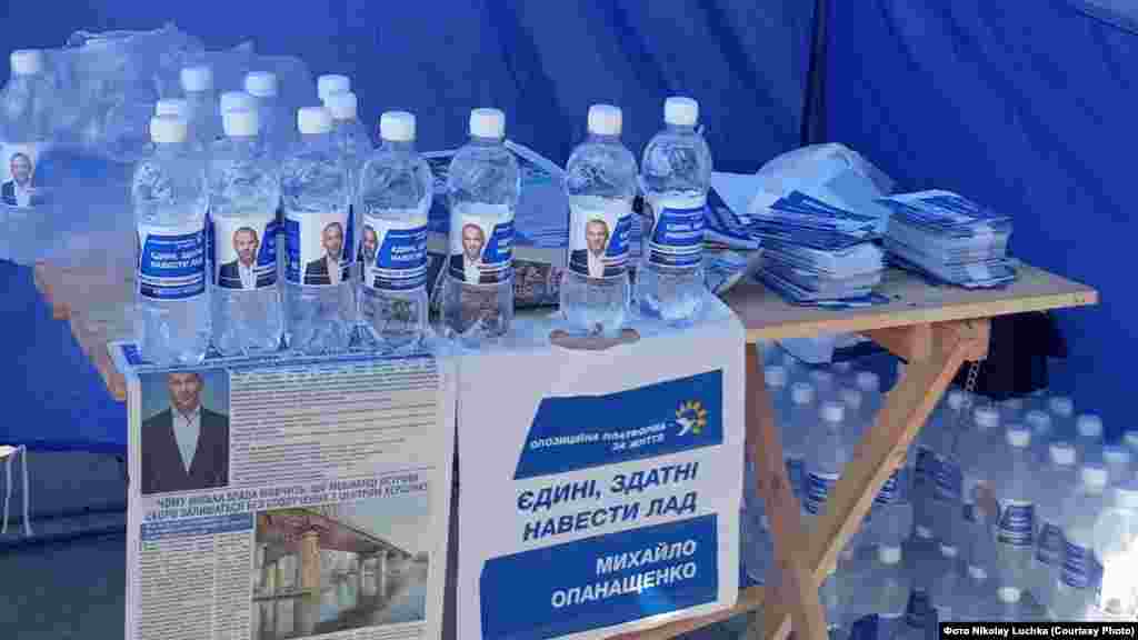 Где? Херсон. Что раздают? Воду. От кого? Михаил Опанащенко, потенциальный кандидат в мэры. Детали: Бутылки с водой, на которых наклеено фото Опанащенко с логотипом ОПЗЖ, начали бесплатно раздавать в брендированных палатках партии и общественном транспорте Херсона еще до официального старта кампании. Воду для этого набирали прямо из системы централизованного водоснабжения. Сам Опанащенко назвал это заботой о людях: «Если вы считаете, что кто-то проголосует за бутылку воды, вы ошибаетесь»