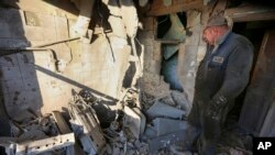 A man examines a damaged apartment building after shelling in Donetsk city on December 15.