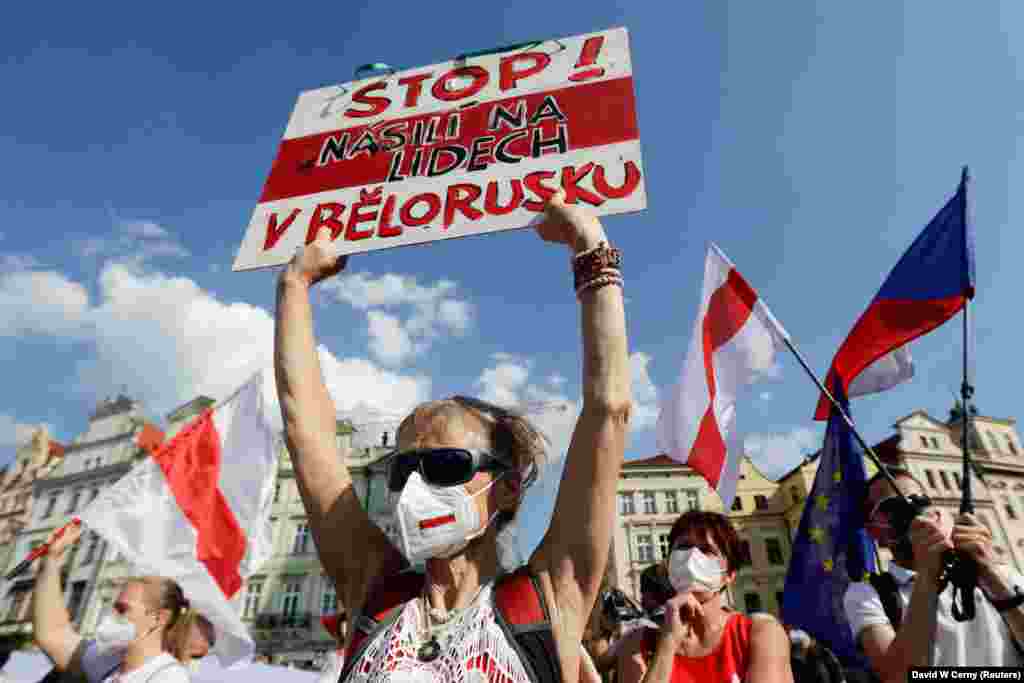 Участница акции держит в руках плакат с надписью на чешском языке: «Прекратите насилие над людьми в Беларуси»