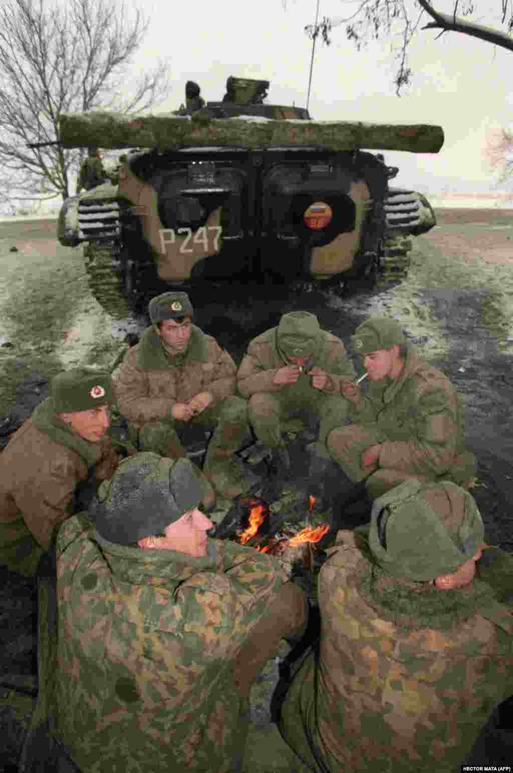 Российские военнослужащие греются у костра в дагестанском Хасавюрте на границе с Чеченской Республикой, ожидая приказа двинуться на Грозный. 22 декабря 1994 года