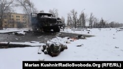 A body lies beside a destroyed Grad missile system near Kharkiv on February 25.