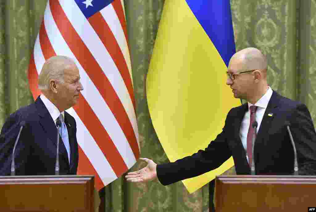 Премьер-министр Украины Арсений Яценюк приветствует вице-президента США Джо Байдена в ходе его визита в Киев в конце 2015 года.    