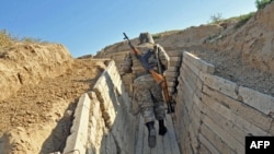 An Armenian soldier runs in trenches on the border of the disputed of Nagorno-Karabagh region.