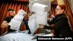 Members of a local electoral commission empty a ballot box at a polling station after the last day of parliamentary elections in Moscow on September 19.