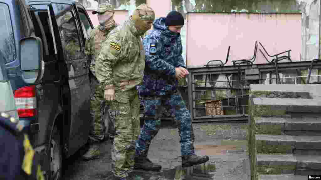 Захваченного украинского моряка Сергея Цибизова ведут в здание Киевского районного суда в Симферополе.  После суда в Крыму всех членов экипажей – 24 украинских военных – арестовали и доставили в СИЗО «Лефортово» в Москве. Прокуратура АРК признала захваченных ФСБ России украинских моряков военнопленными