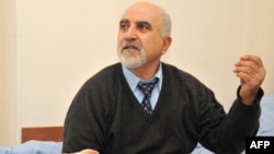 Presidential candidate Paruyr Hairikian speaks as he sits on his bed in a hospital room in Yerevan on February 5, less than a week after being shot in the right shoulder.