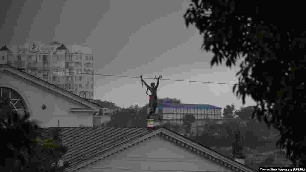 На тлі темного старого неба – фігура Мельпомени з лавровим вінком у руці та віялом – у інший