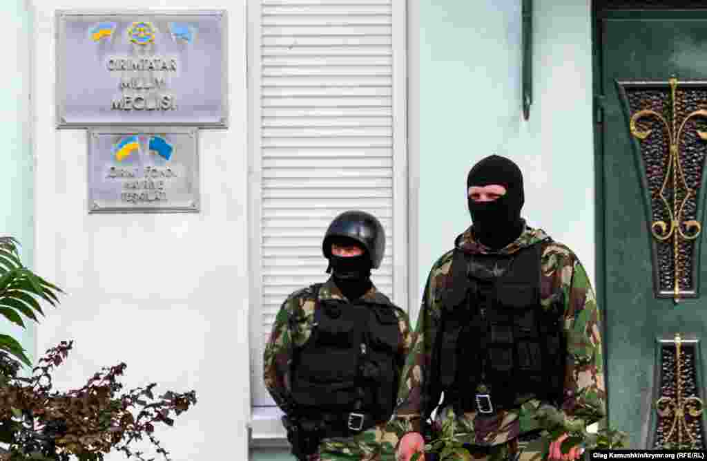 Возле входа в Меджлис стоят вооруженные автоматчики в масках. 