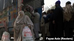پېښور: د سوک پر غاړه له ولاړې لارۍ خلک اوړه رانیسي. ۲۰۲۰، ۲۰ جنوري