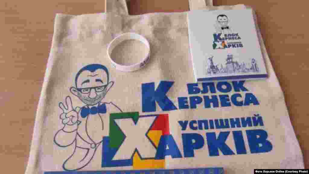 Где? Харьков. Что раздают? Подарки для школьников От кого? Геннадий Кернес, мэр Харькова. Детали: 1 сентября в харьковских школах бесплатно раздавали наборы для учащихся с символикой партии действующего мэра «Блок Кернеса – Успешный Харьков». Среди содержимого пакетов – блокноты, браслеты, календарики, защитные маски. При этом, как сообщили в Департаменте образования Харьковского горсовета, это не было политической рекламой: «Когда ребенок получил подарок и забрал его домой – это не политическая реклама. Кернес – успешный мэр успешного города. Почему бы ему не передать школьникам сувениры?»