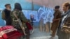 Taliban militants gather by a picture of their leader, Mullah Haibatullah Akhundzada, in Kabul, who was named supreme leader of the Taliban-led government.
