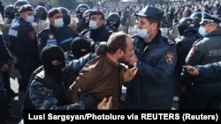 A man is taken away by law enforcement officers during an opposition rally to demand the resignation of Armenian Prime Minister Nikol Pashinian
