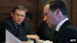 Russia - Russia's President Dmitry Medvedev (right) looks through some documents as he meets opposition leaders, including liberal politician Vladimir Ryzhkov (left).