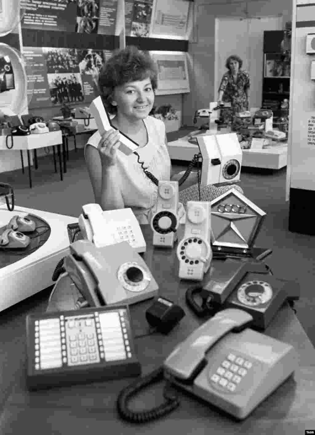 A woman displays products and a State Quality Mark of the U.S.S.R., the highest certification of quality, in the shop at the Perm telephone production plant in 1982.