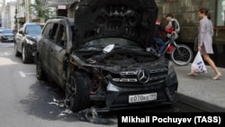 Сгоревший автомобиль перед бизнес-центром, в котором находится офис коллегии адвокатов Pen&Paper