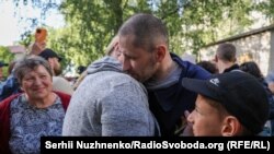 Un prizonier de război ucrainean eliberat își îmbrățișează soția și copilul joi, 26 iunie.