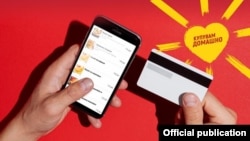 A poster promoting the "Buy At Home" payment card in North Macedonia.