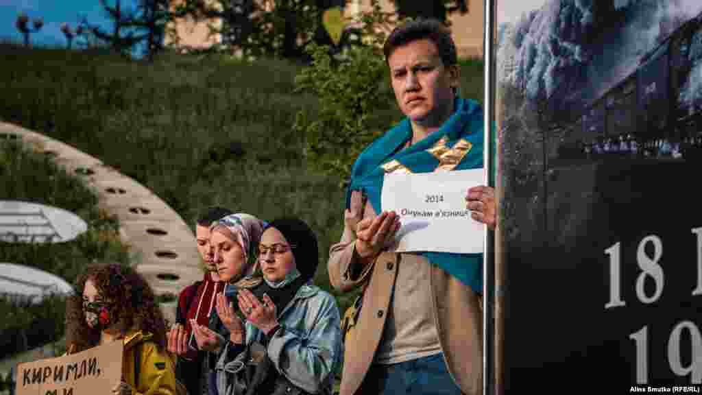 Чоловік стоїть із плакатом, де написано «2014. Онукам в'язниця»