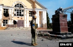 Украинский военнослужащий рядом с разрушенным памятником Ленину на центральной площади в Судже, Курская область, 21 августа 2024 года