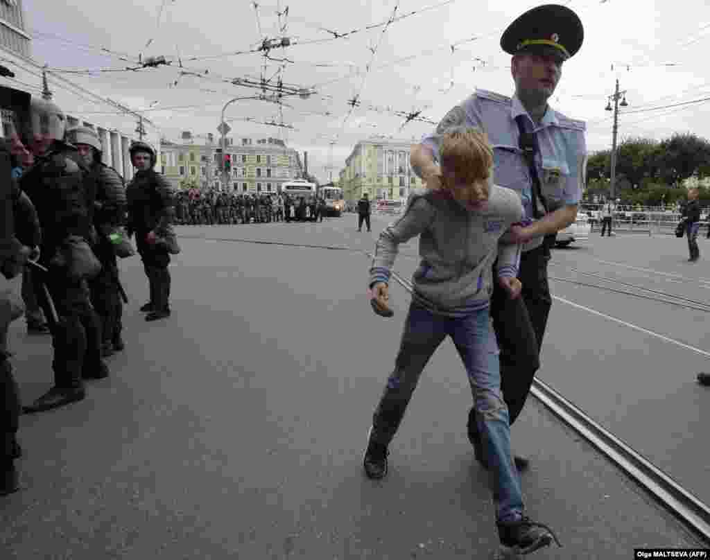 A child is led away by a police officer during a protest in St. Petersburg. 