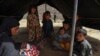 Afghan refugees sit inside a makeshift tent shelter on the outskirts of Quetta on September 6.