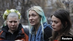 Activists from the Ukrainian women's rights group Femen hold an impromptu press conference on their return to Kyiv (from left to to right: Aleksandra Nemchinova, Inna Shevchenko, and Oksana Shachko).