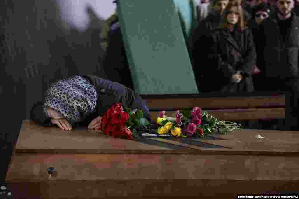 The mother of fallen soldier Danylo Lyashkevych weeps over his coffin during his funeral in Kyiv on November 8, 2024. 
