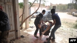 A rebel is carried away after being wounded in fighting near Misurata airport in Libya.