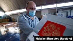 Проверка переносной урны для голосования на избирательном участке в селе Иволгинск, Республика Бурятия, 16 сентября 2021 г.