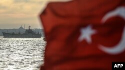 A Turkish flag flies on a ferry as Russian warship, the BSF Saratov 150, sails through the Bosphorus off Istanbul en route from the Black Sea to the eastern Mediterranean late last year.