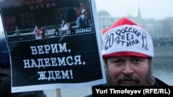 One of the tens of thousands of Moscow protesters holds a sign saying: "We believe, we hope, we wait!" His hat says: "Russian without Putin" 2012.