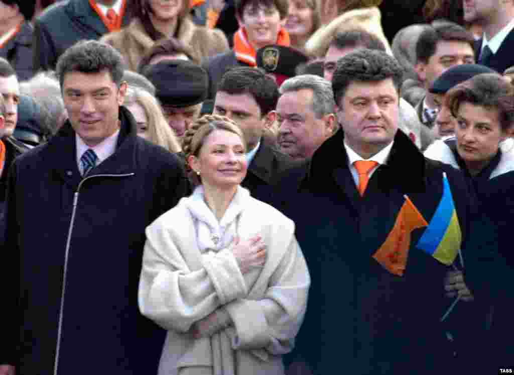 Немцов рядом с Юлией Тимошенко на инуагурации Президента Украины Виктора Ющенко в 2005 году. Справа от Юлии Тимошенко стоит Петр Порошенко, самый богатый бизнесмент в то время, а сейчас Президент Украины. 