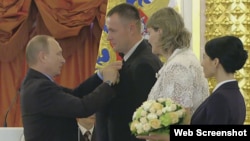 Jehovah's Witness Valery Novik (second left) and his wife, Tatyana (second right), accept a Family Glory award from Russian President Vladimir Putin at the Kremlin.