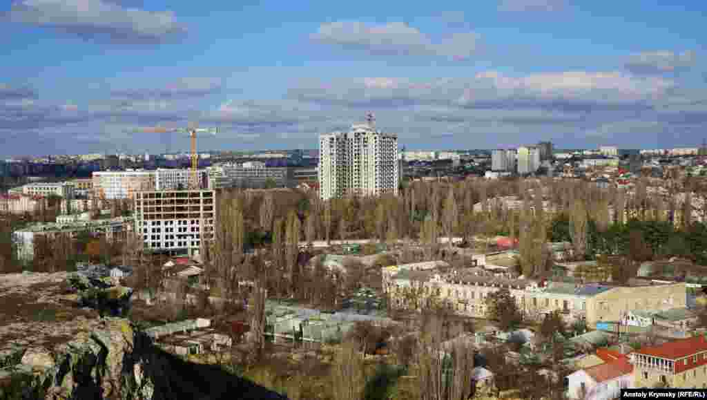 С Петровских скал хорошо видно, как ударными темпами застраивается одна из прежних зеленых зон города – сквер вокруг снесенного кинотеатра «Мир». В центре кадра – 19-этажный «люксовый» клубный дом «Триумф» строительной фирмы «Владоград»