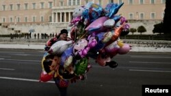 Уличный продавец воздушных шаров перед зданием парламента в Афинах, январь 2015 г.