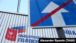 RUSSIA -- RYAZAN, MARCH 25, 2020. An "End Of One-Way Traffic Road" road sign and a billboard for the forthcoming national referendum on proposed amendments to the Russian Constitution.