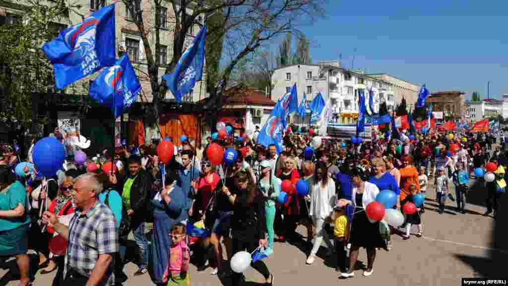На первомайскую демонстрацию многие керчане взяли с собой детей. Люди несут в руках флаги, цветы, воздушные шары. 